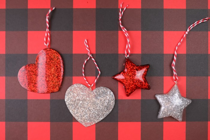 glitter resin heart and star ornaments on a plaid background