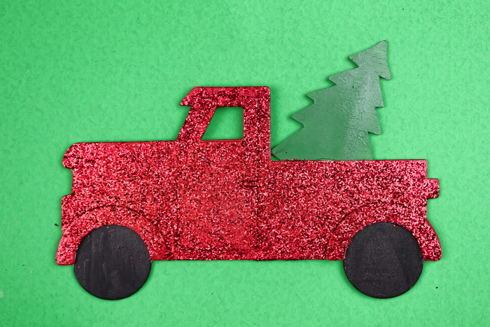 painted and glittered wood truck sign on a green background