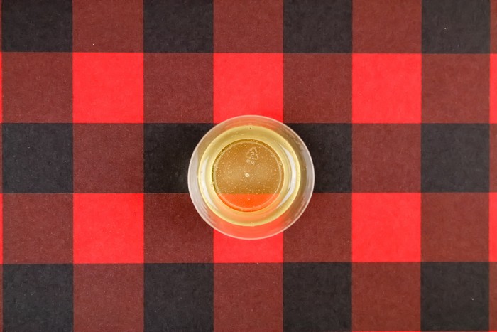 mixed resin in a small cup on a plaid background