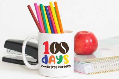 100 Days Countless Coffees SVG design on a white mug full of colored pencils, and apple and a stapler