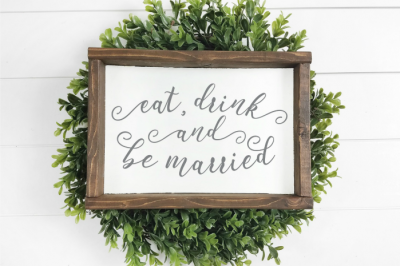 farmhouse style Eat, Drink and Be Married sign on a green wreath