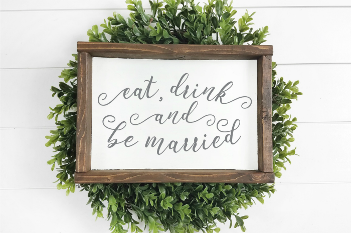 farmhouse style Eat, Drink and Be Married sign on a green wreath