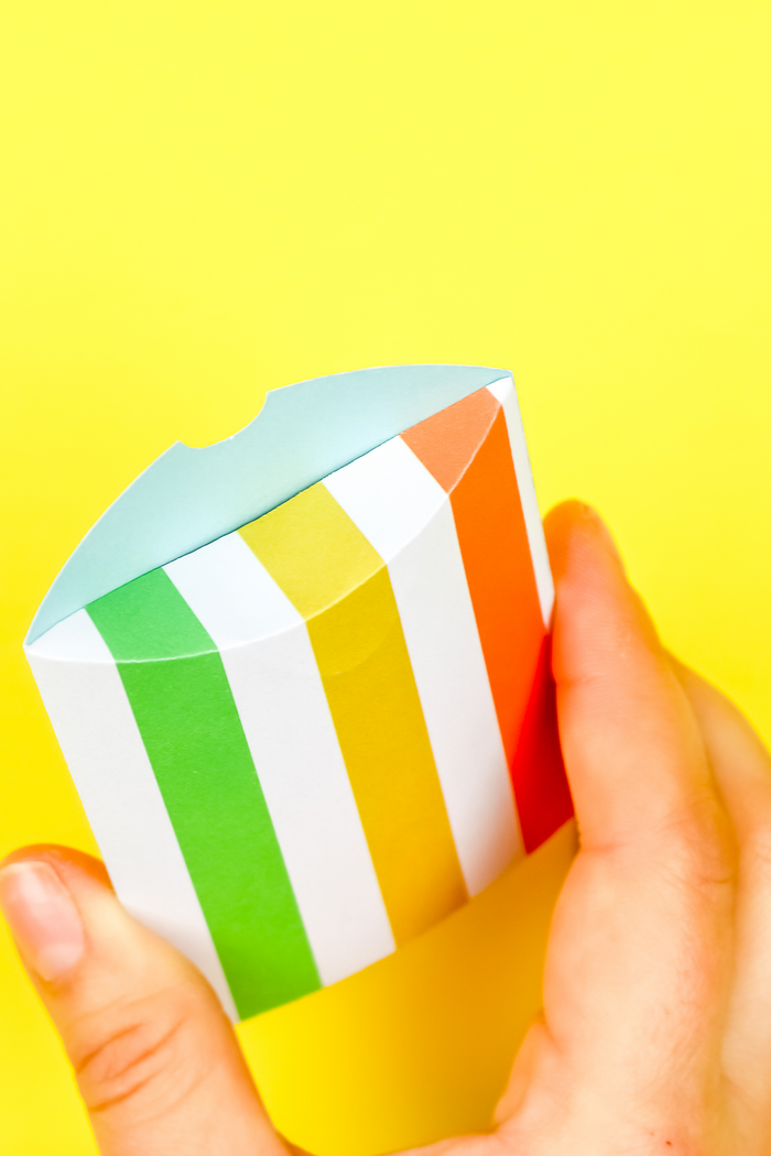 hand closing a colorful pillow favor box