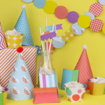 Colorful DIY paper party supplies on a yellow background