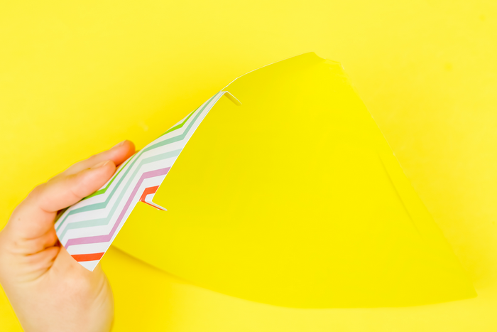 hand assembling a colorful paper party hat