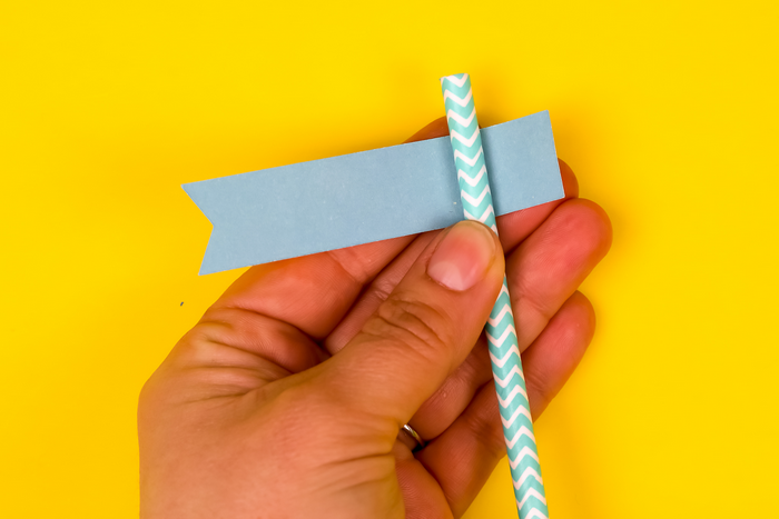 hand assembling a paper party straw flag