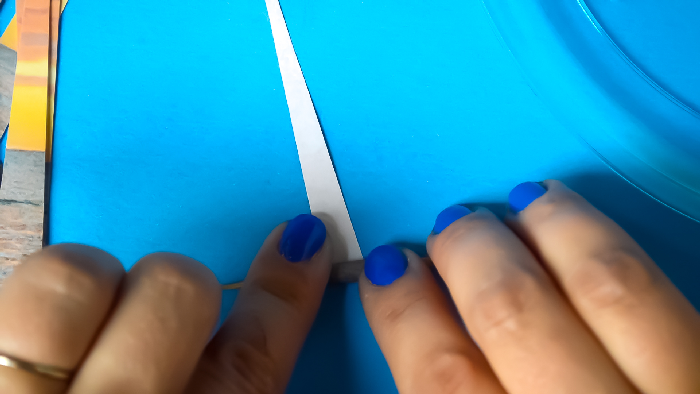 woman's hands rolling paper around a toothpick