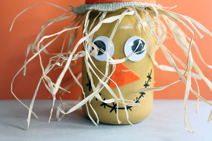 scarecrow painted mason jar on an orange background