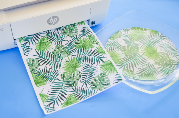 Printer with tropical paper on a blue background