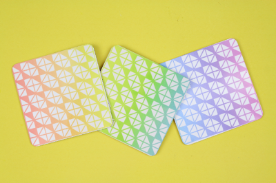 Colorful Infusible Ink coasters on a yellow background