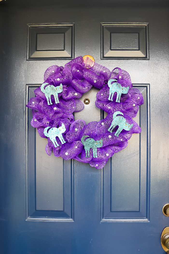 Halloween purple mesh wreath with cat shapes on a blue door