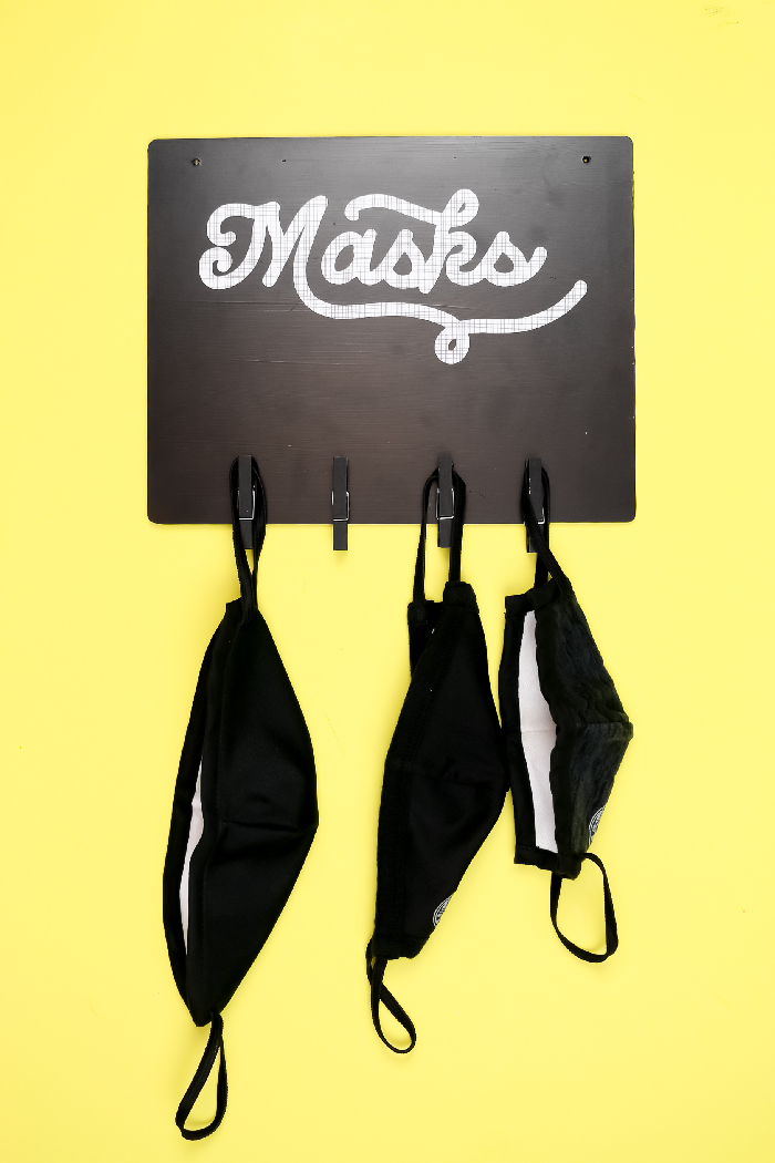 black vinyl mask sign on a yellow background
