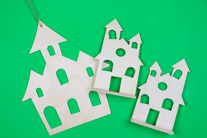 unpainted wooden halloween houses on a green background