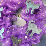 purple mesh wreath with black cat shapes and rhinestones on a blue door