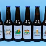 Beer bottles with printable Oktoberfest sticker labels on a blue background