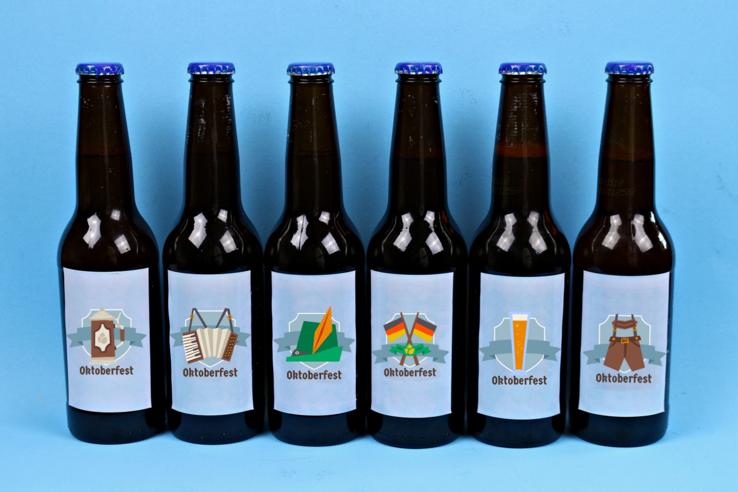 Beer bottles with printable Oktoberfest sticker labels on a blue background