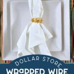 white napkin wrapped in gold wire napkin ring on a place setting