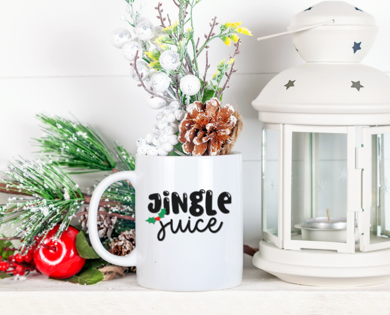Jingle Juice SVG design on a white mug next to a lantern and greenery