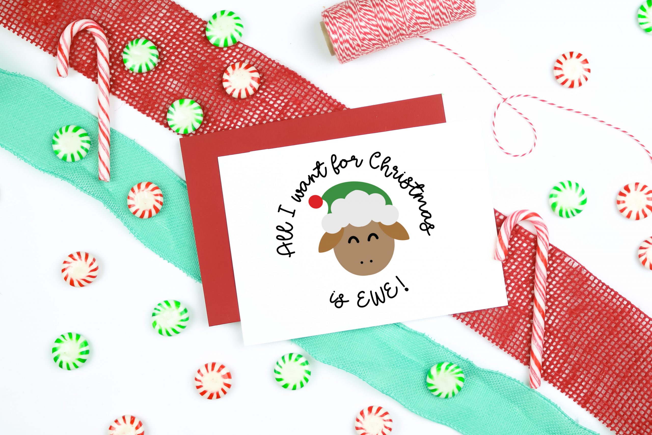 All I Want for Christmas is EWE SVG design on a christmas card with ribbon, candy, and twine