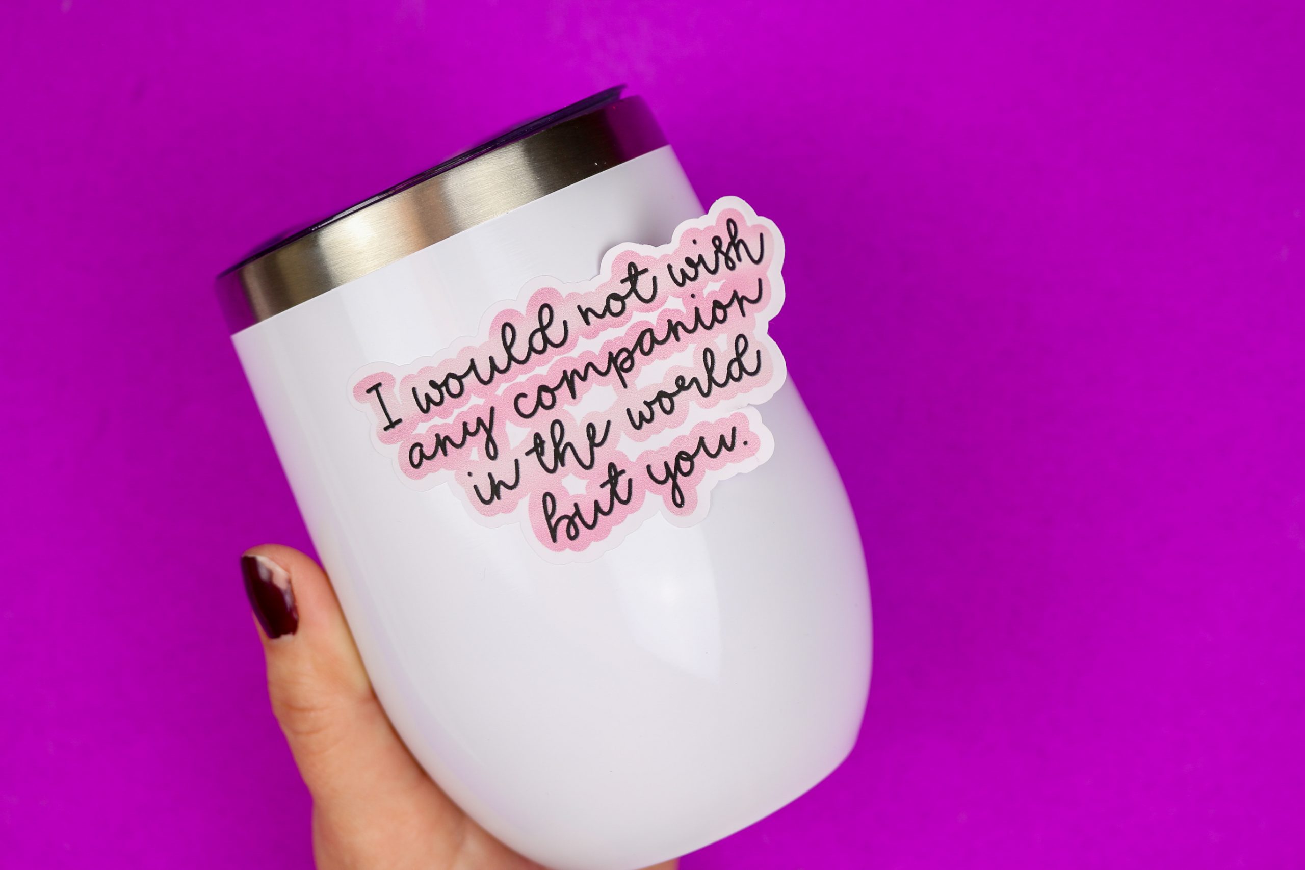 Hand holding a white wine tumbler with printable Shakespeare sticker