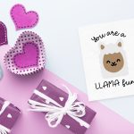llama valentine near purple wrapped gifts and valentine decor