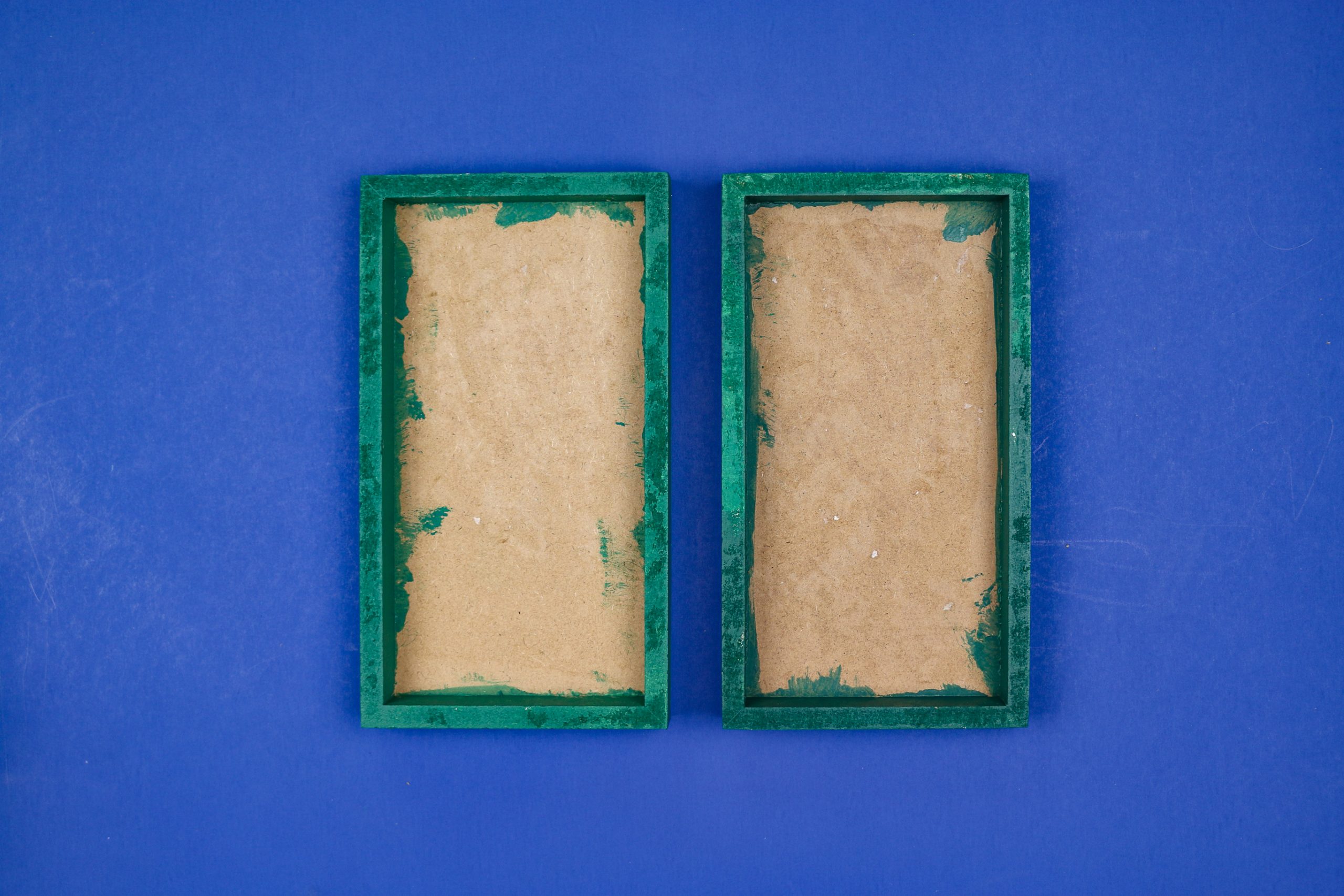 unfinished Green painted frames on a blue background