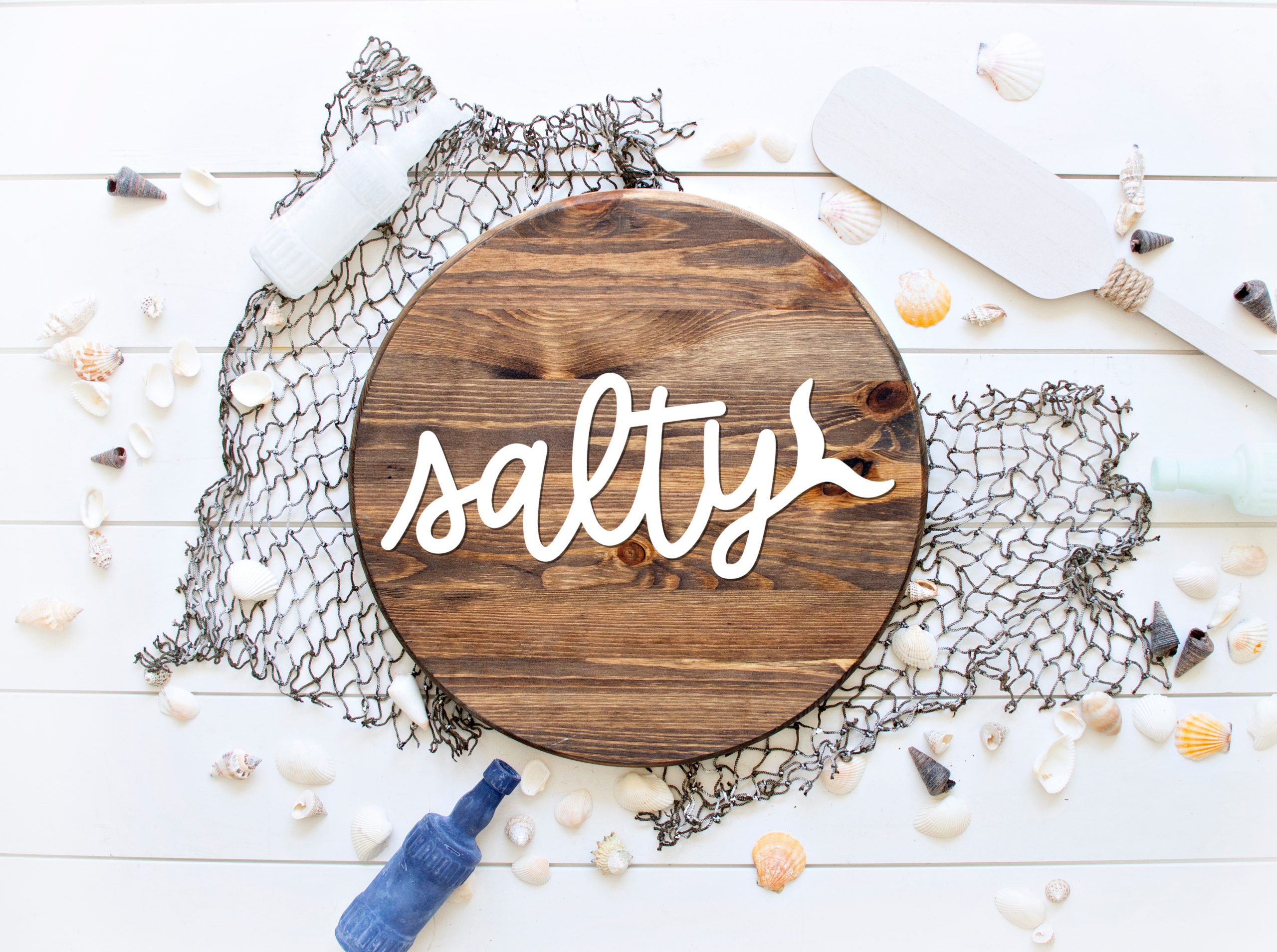 Salty SVG on a wood circle sign with beach decorations
