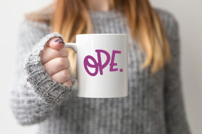 blond woman holding a mug with OPE design