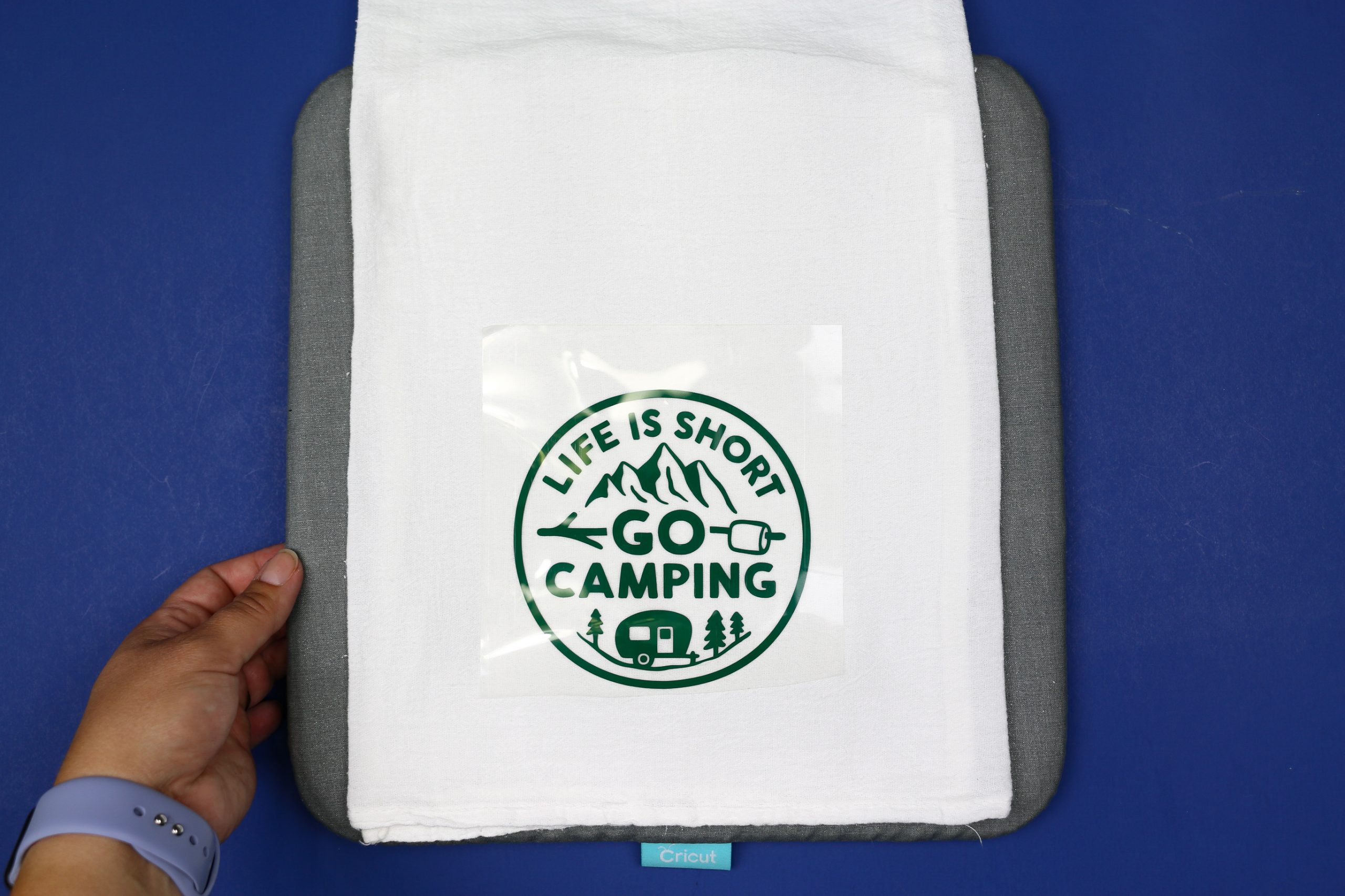 tea towel on an EasyPress mat with a green camping design