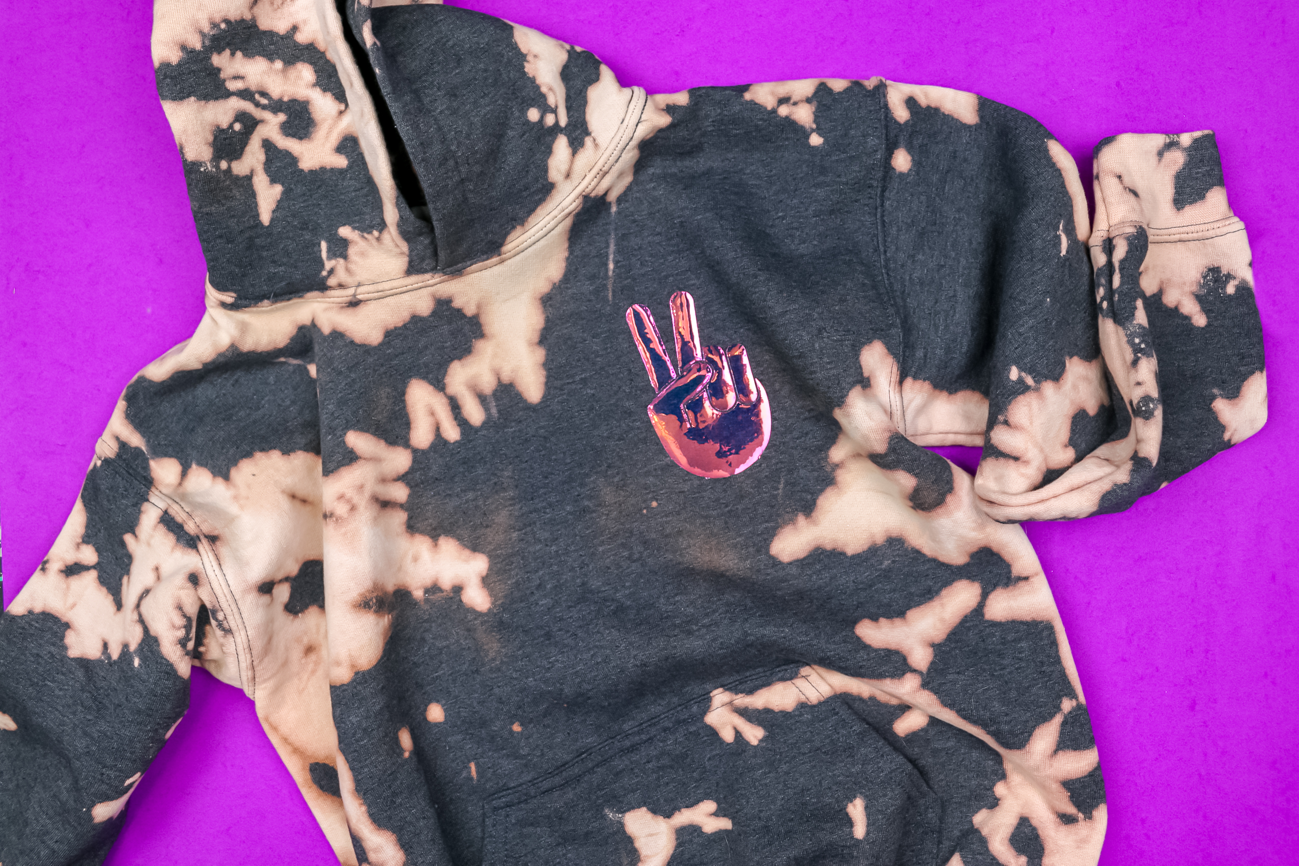holographic iron on vinyl cut into a peace sign on a sweatshirt