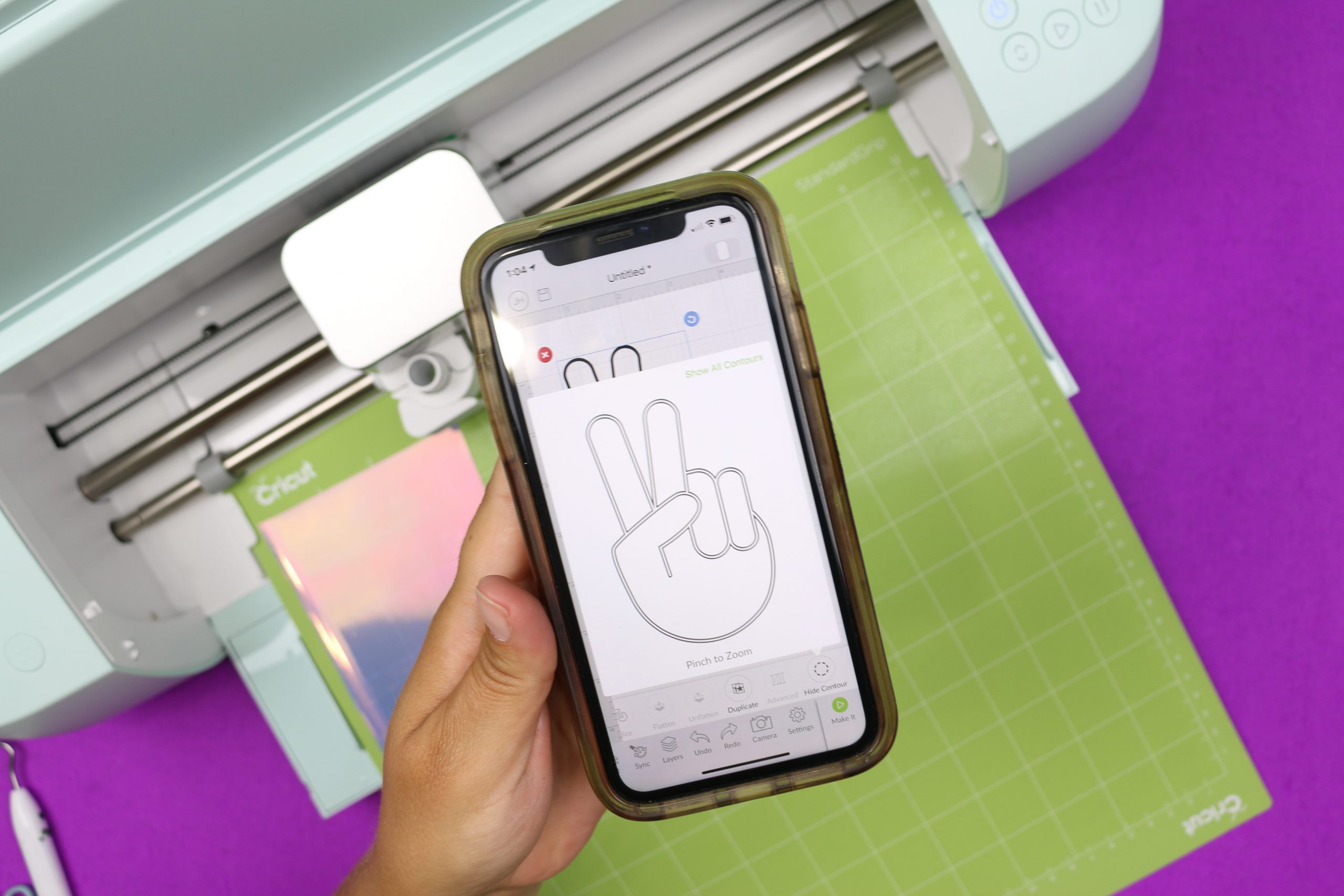 hand holding a smartphone displaying Cricut Design Space