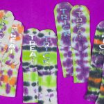 tie dyed socks with TRICK and TREAT in glitter vinyl on a purple background