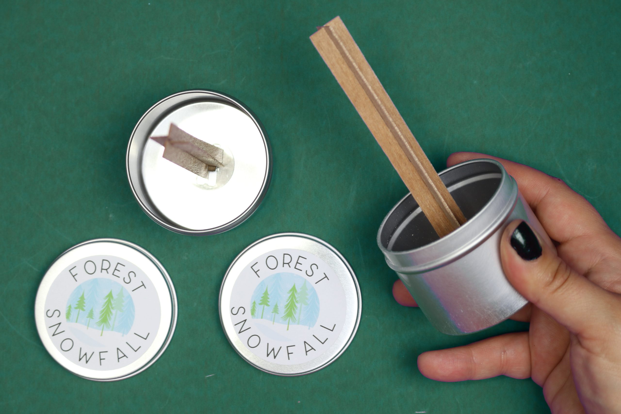 inserting wood wicks into candle tins