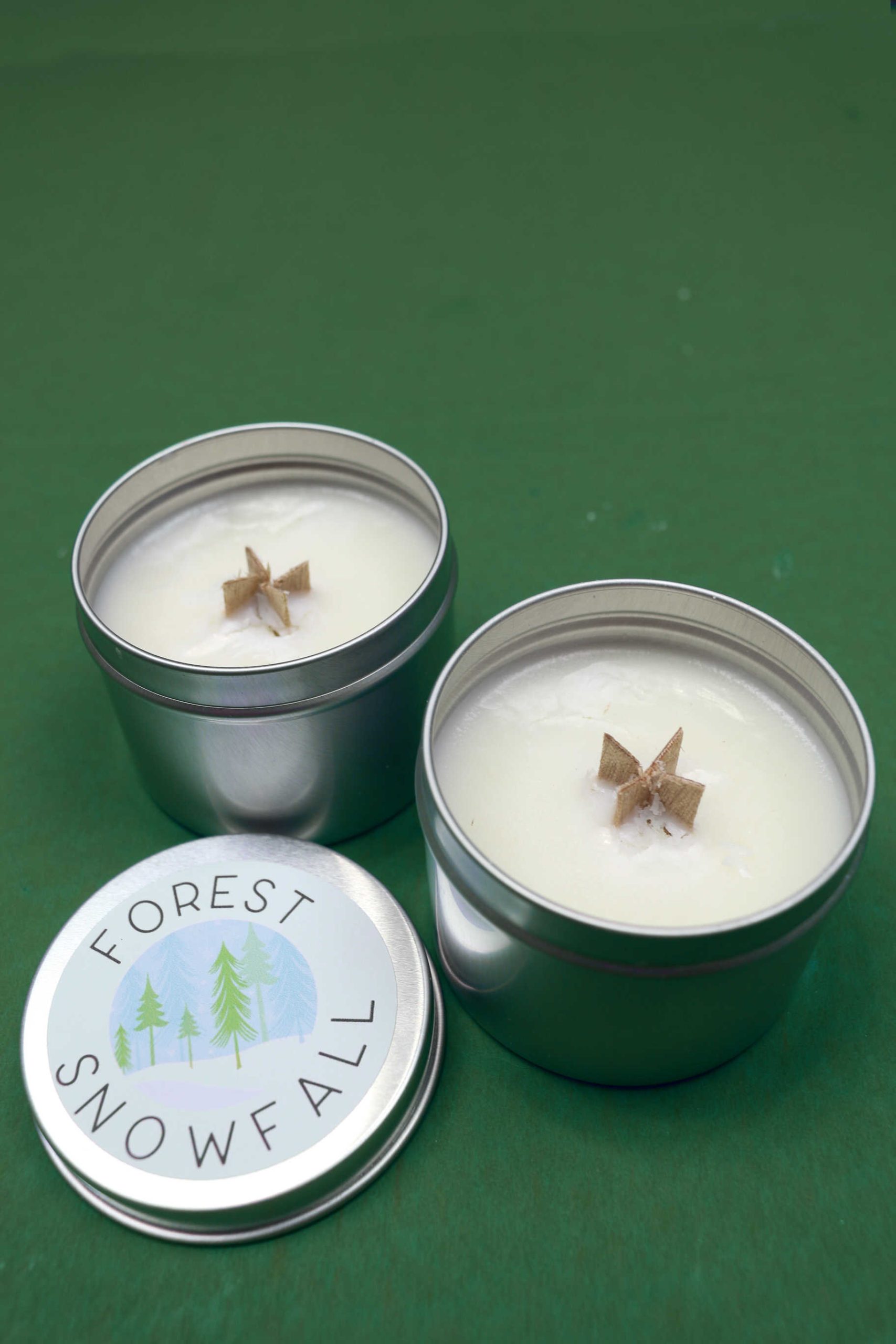 two wood wick candles in tins