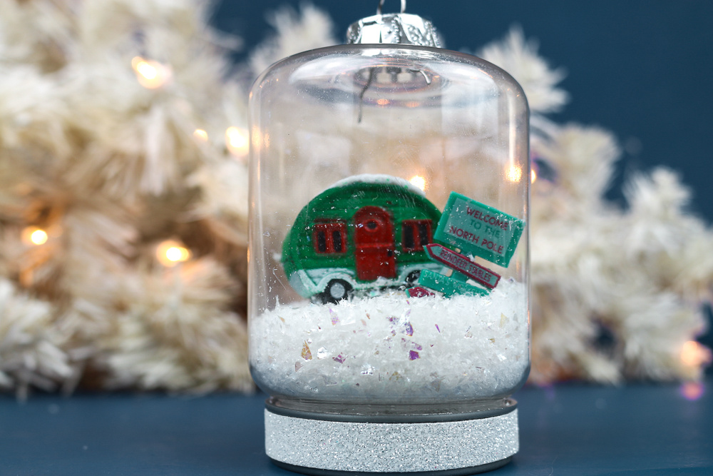 closeup of a jar ornament with snow, a vintage camper, and signs