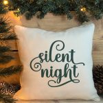 silent night SVG on a pillow near a Christmas tree