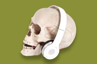 plastic skull wearing headphones on a green background