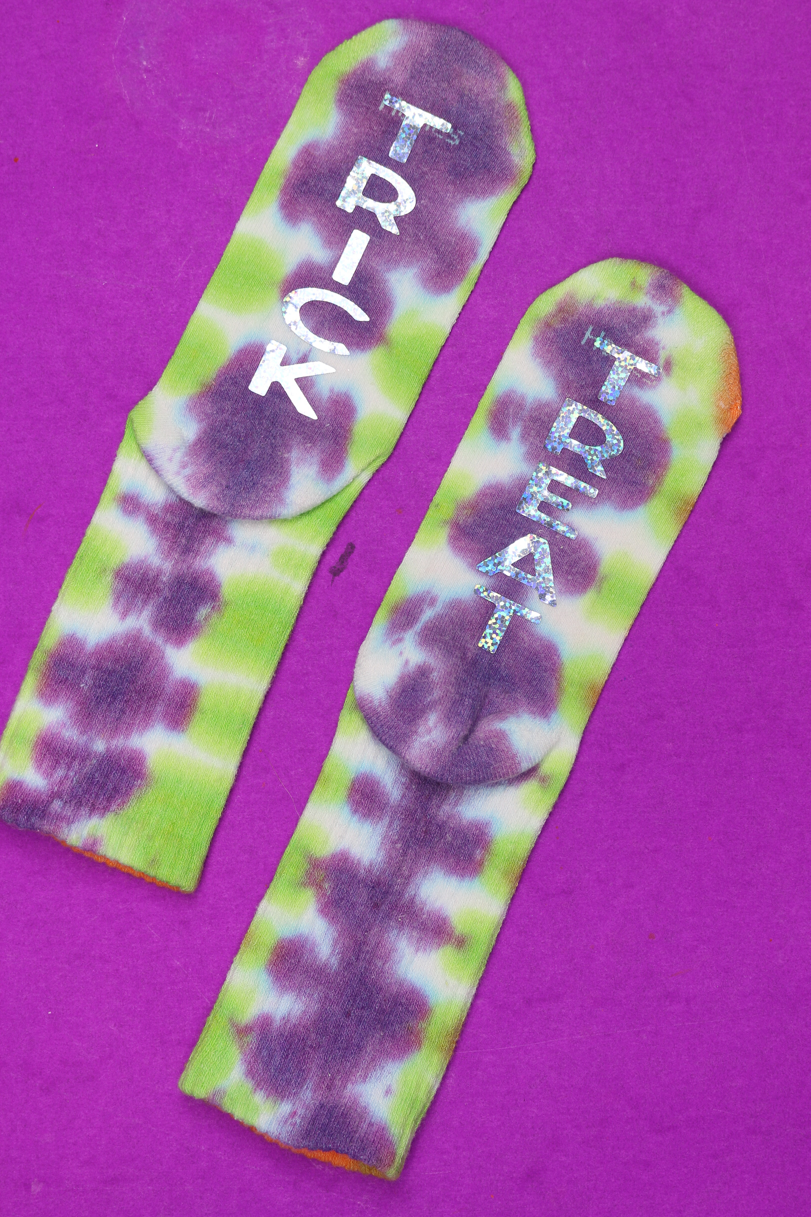 tie dyed socks with TRICK and TREAT in glitter vinyl on a purple background