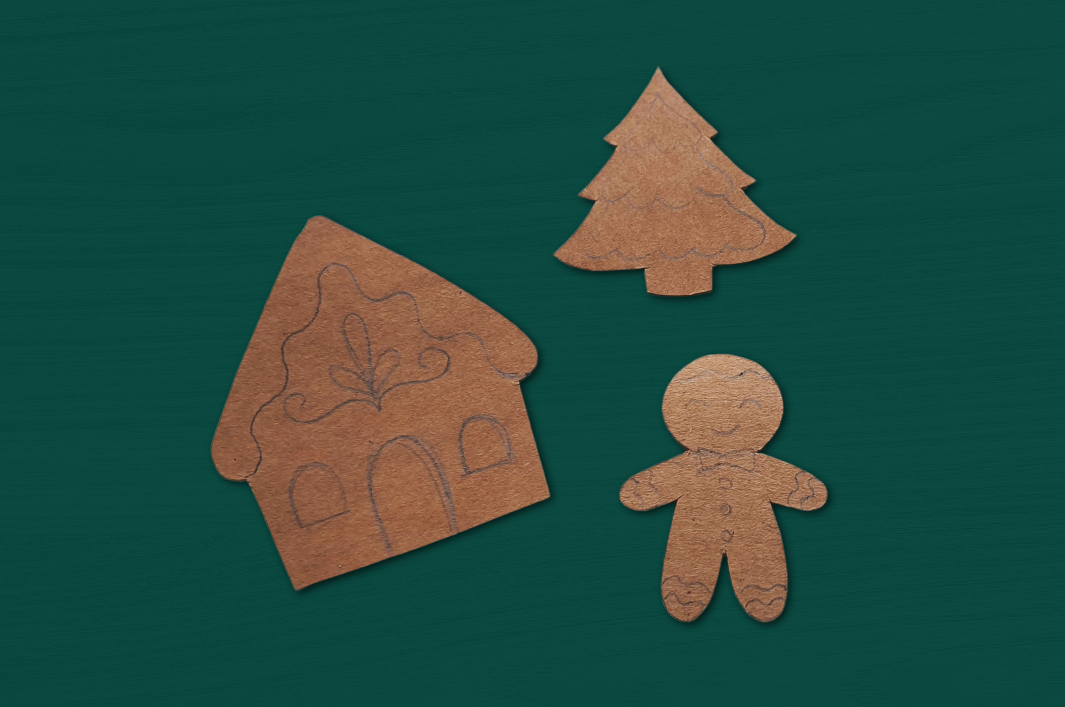 undecorated paper gingerbread ornaments with designs sketched in pencil