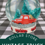 closeup of a finished vintage Christmas truck snow globe on a buffalo check background