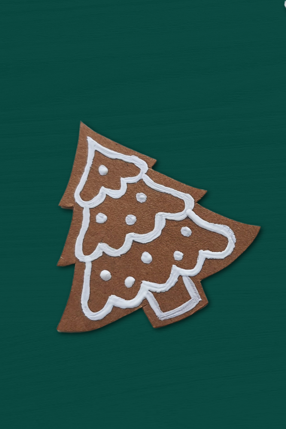 paper gingerbread tree ornament on a green background