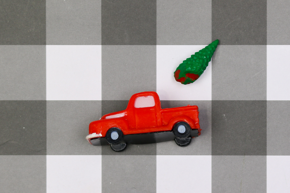 plastic tree removed from dollar store truck figurine on a buffalo check background