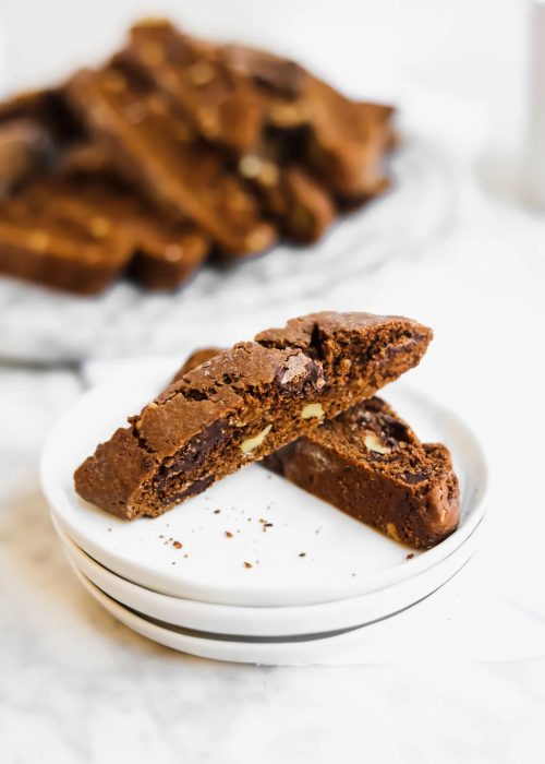 chocolate and coffee biscotti on a stack of white plates