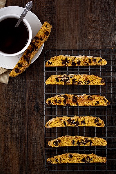 pumpkin chocolate chip biscotti by a cup of coffee