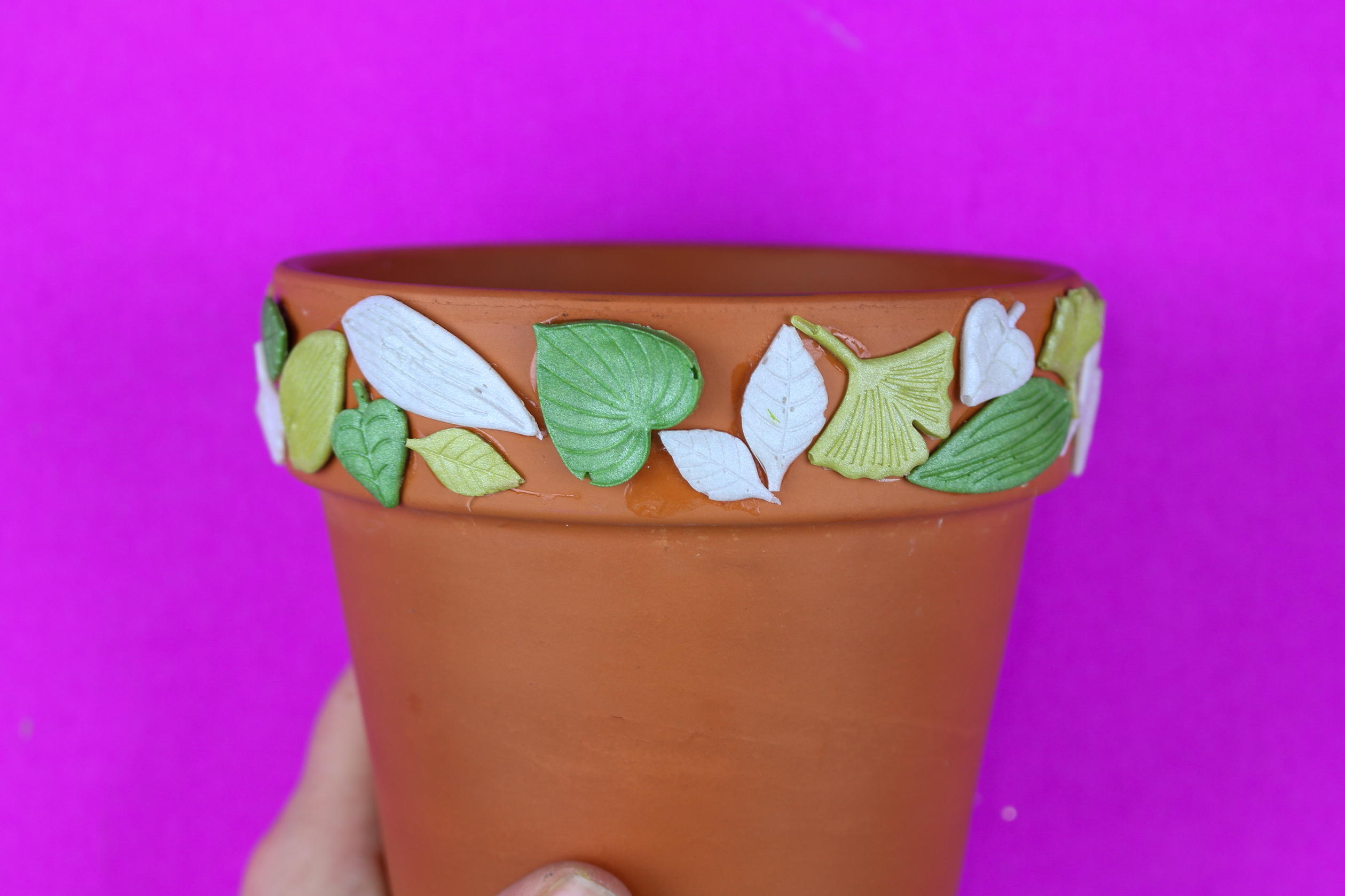 terracotta pot decorated with leaf shapes