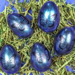 five blue butterfly easter eggs on reindeer moss
