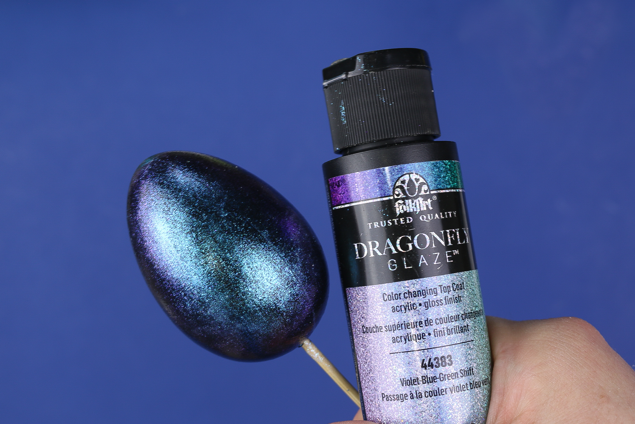 a bottle of dragonfly glaze and an egg painted with it