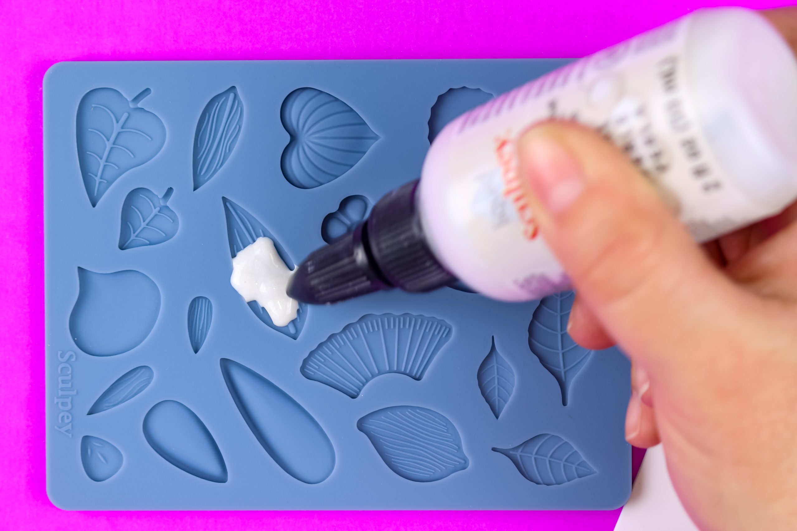 hand squeezing Liquid Sculpey into a silicone mold