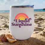 Liquid Sunshine SVG on a Wine Tumbler that is sitting on a beach