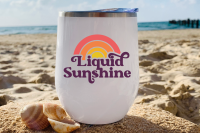 Liquid Sunshine SVG on a Wine Tumbler that is sitting on a beach